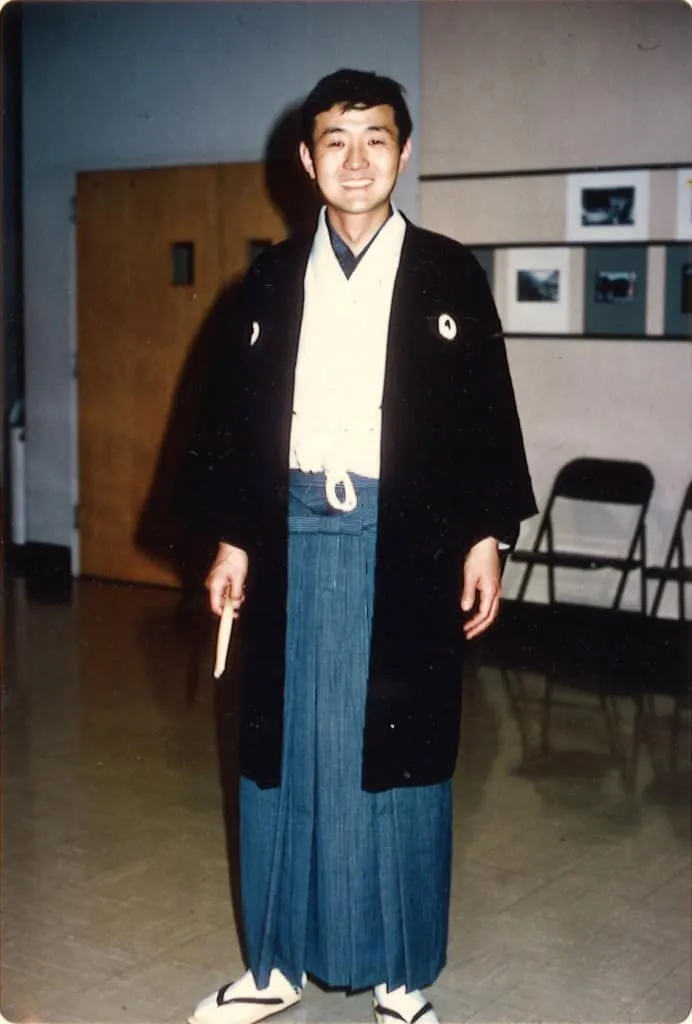 Performing on stage in traditional Japanese formal attire (montsuki hakama) during 'Song of Asia'