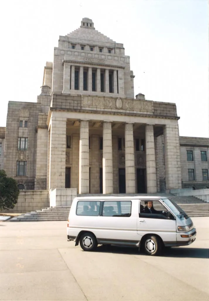Station wagon driving in front of the Diet building